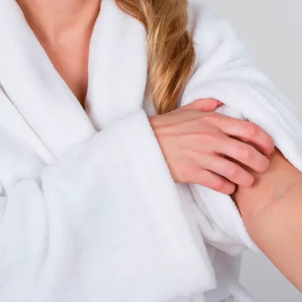 a woman scratching her arm after taking a shower 