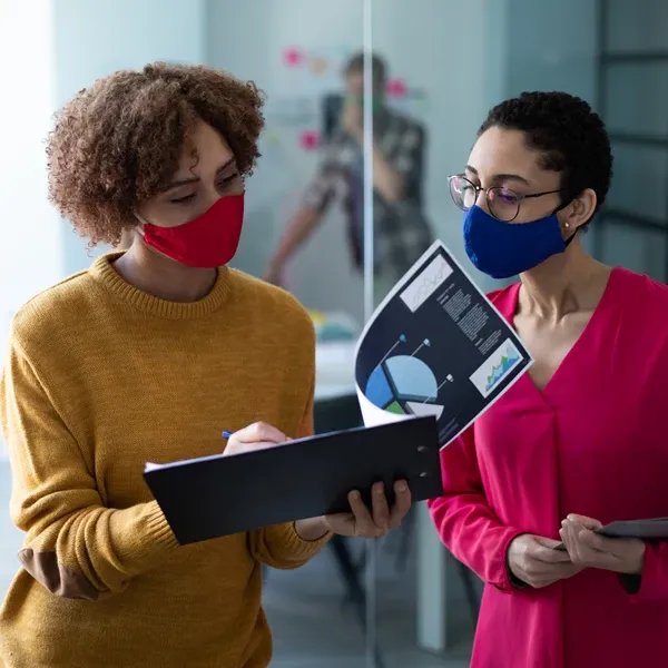 two women discussing while looking at file