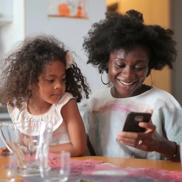 A girl with a mother using mobile phone