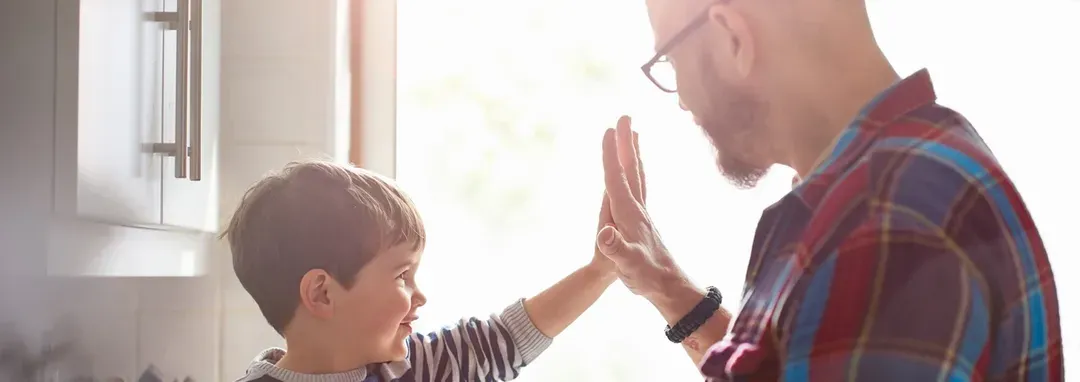 A father with a kid doing high five