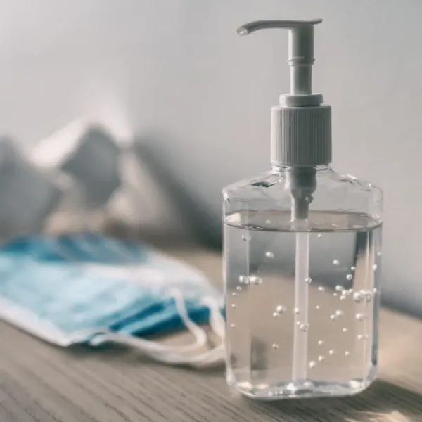face masks and hand sanitizer bottle on a table