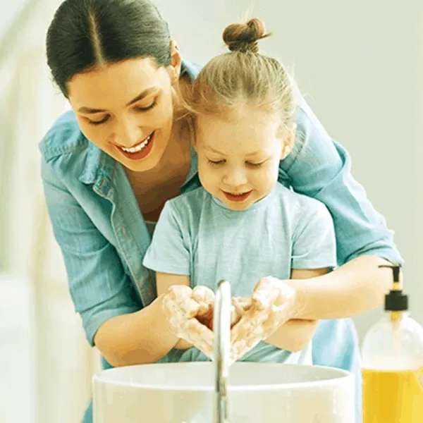 Mother and child washing hand together, helping to kill germs.