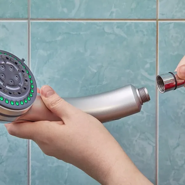 Person connecting showerhead to pipe 