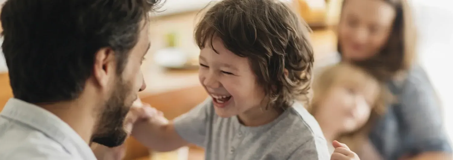 Young father with beard is playing with his son